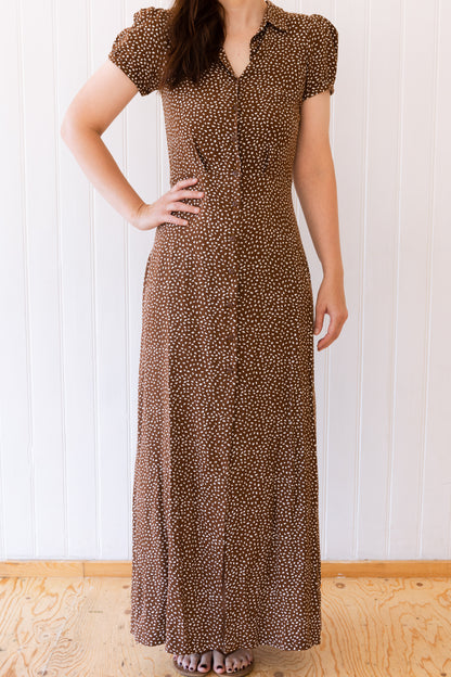 Woman wearing a long vintage inspired maxi shirt dress in brown and white.