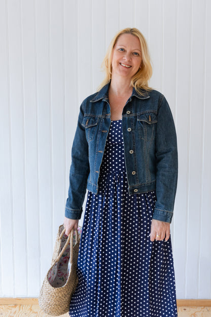 Blue and white polka dot vintage inspired summer dress styled with denim jacket and straw bag.