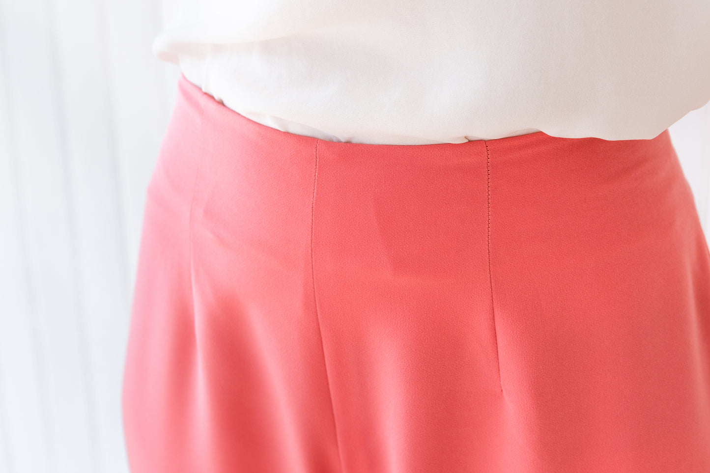 Close up of the fitted waistline of a pair of wide leg vintage inspired trousers.