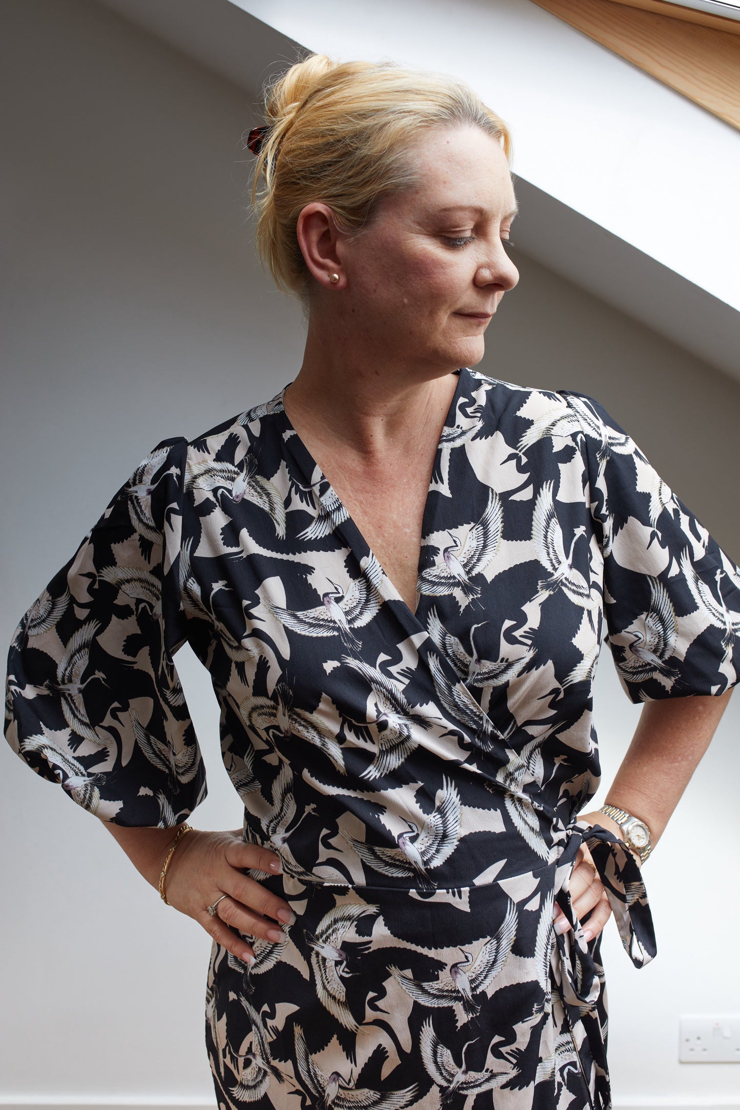 Close up of the top half of a vintage inspired wrap dress in a black fabric with white birds.