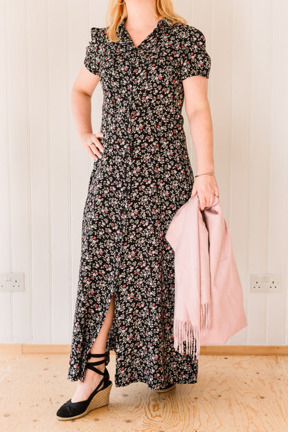 Woman wearing a vintage inspired maxi dress in a floral fabric accessorised with a pink pashmina.